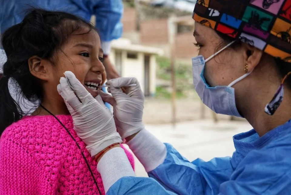 Atención odontológica a una niña en una campaña de salud